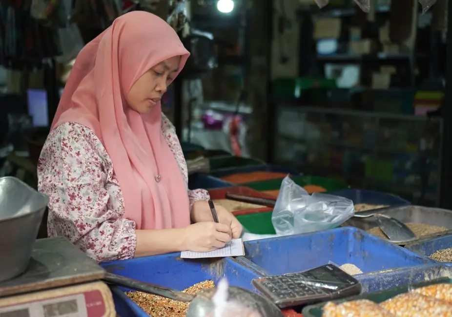 Pemilik UMKM mencatat pesanan pelanggan melalui ponsel